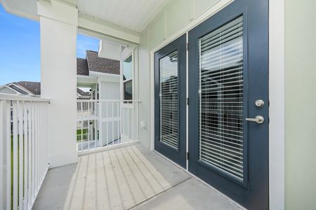 1 Bedroom Apartments in Santa Rosa Beach, FL - The Southern - Large Private Balcony with Blue Glass Door, Concrete Flooring, and Covered Overhead.